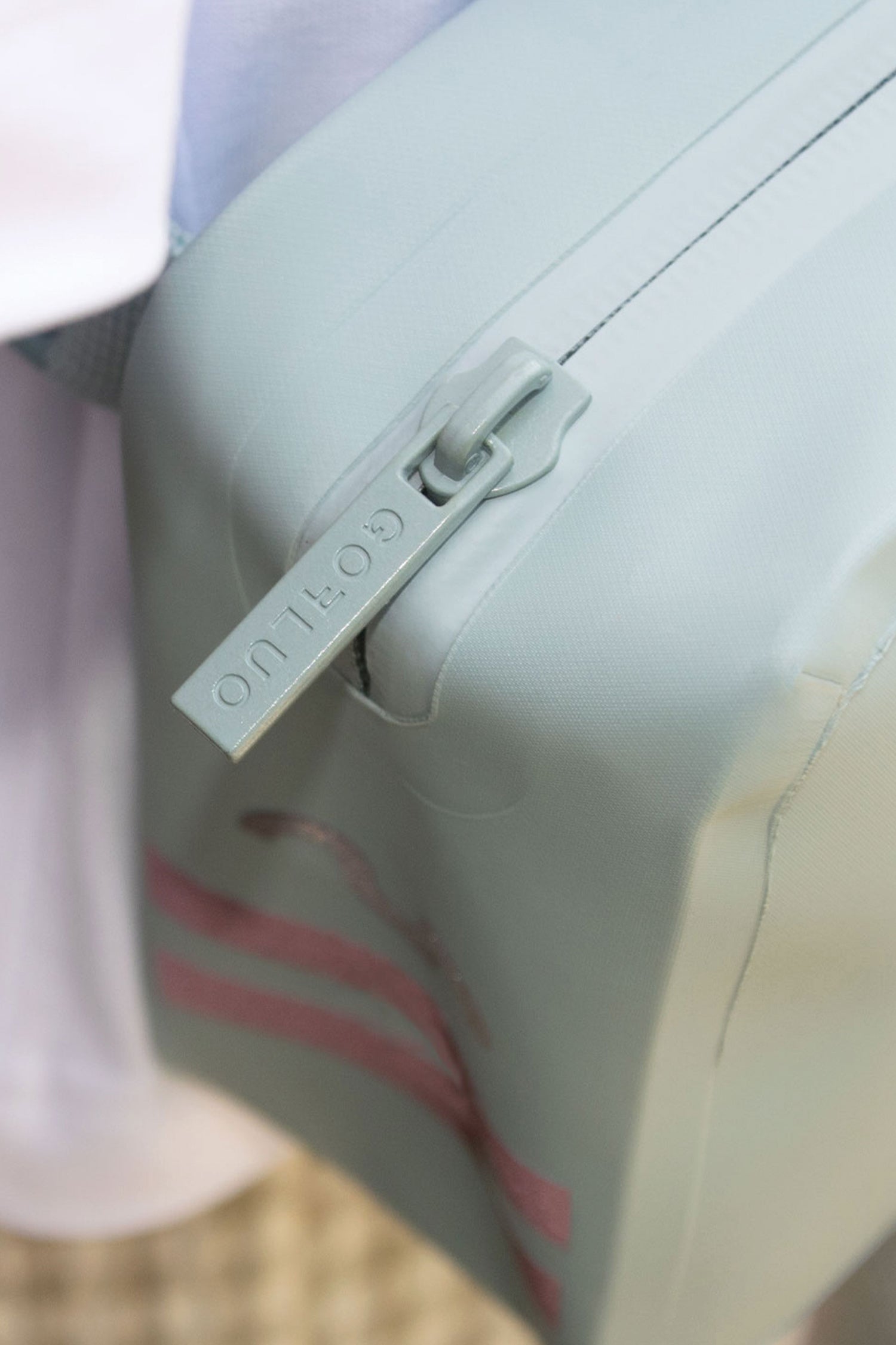 Close-up of a gray bag with a visible brand logo on a blurred background