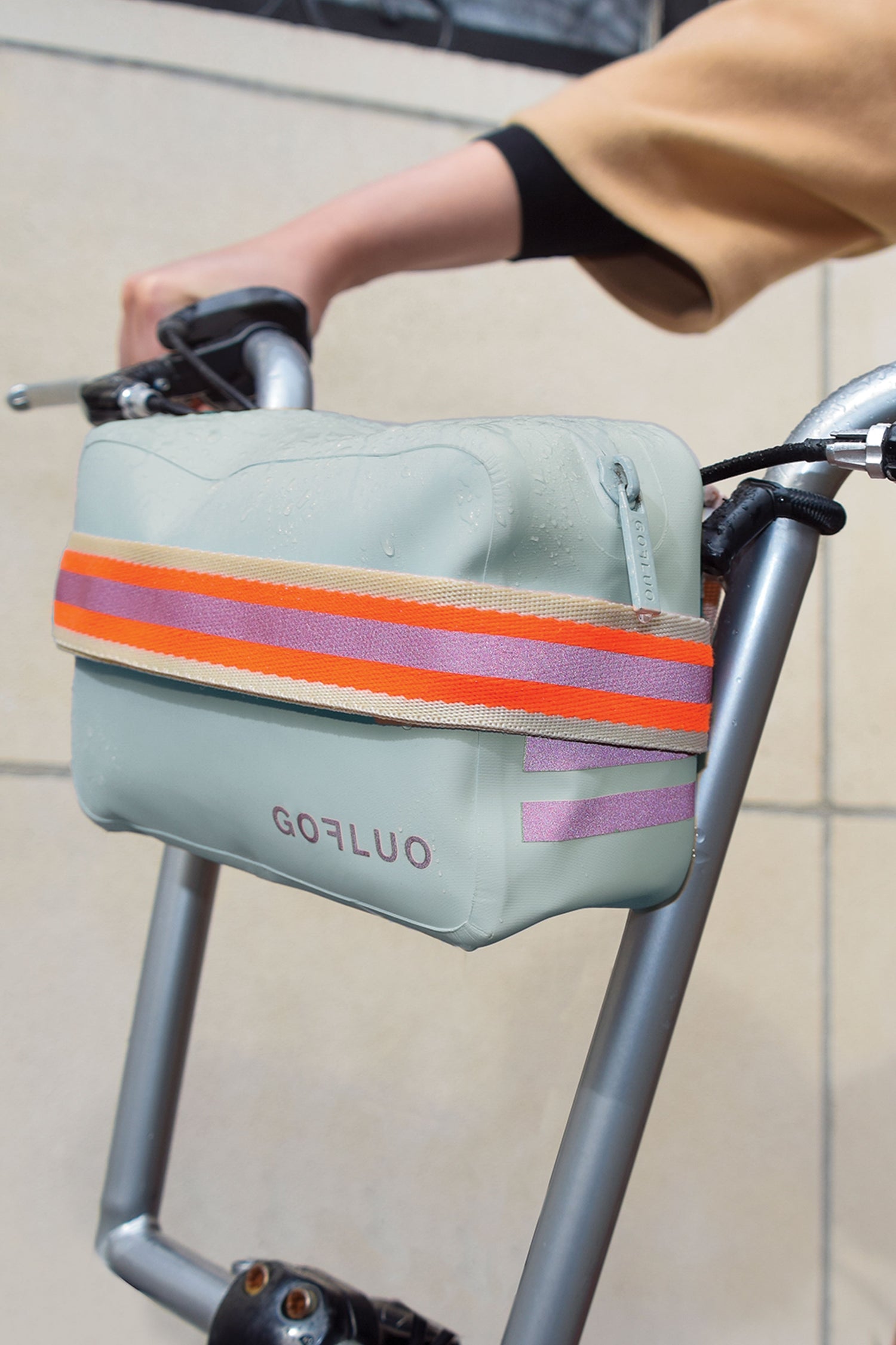 Bicycle handlebar bag with colorful strap attached to a bike, brand 'Gofluo' visible