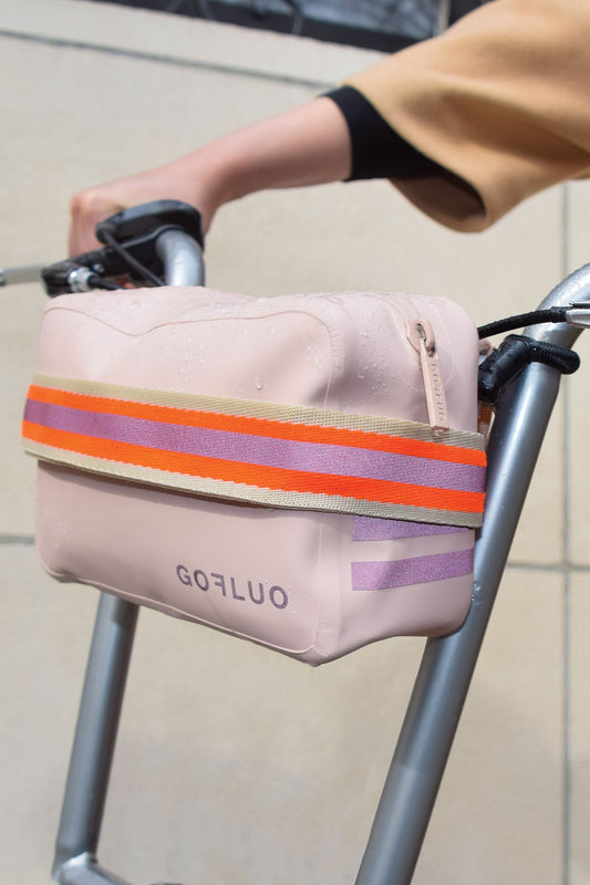 Pink bag with orange and purple stripes attached to a stroller handle.