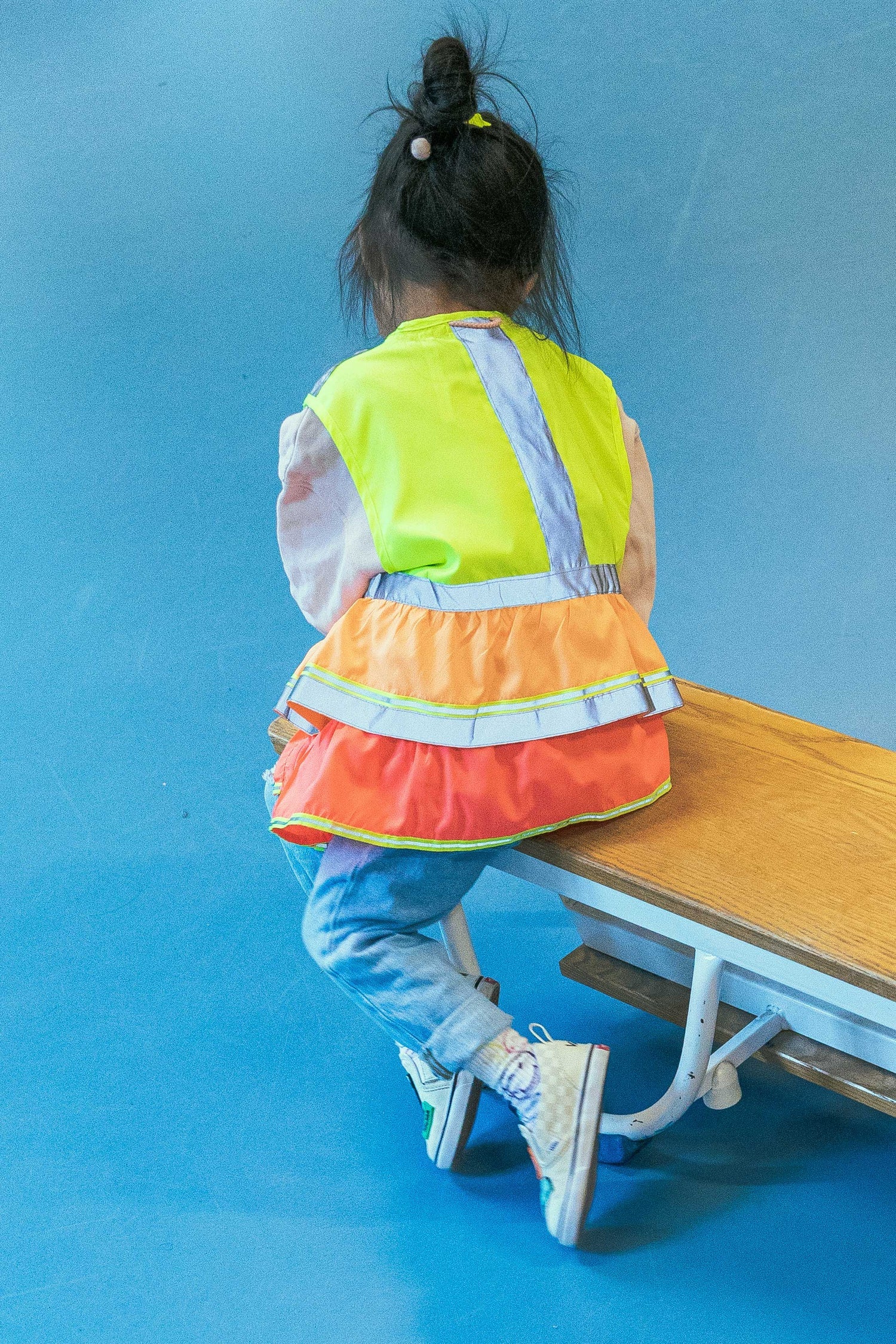 Child wearing a high-visibility safety vest on a blue background