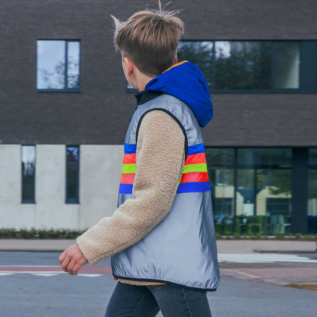 Person wearing a colorful striped jacket with a building in the background
