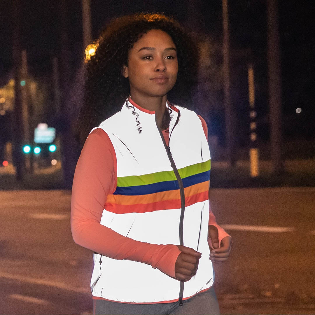 Person wearing a colorful striped vest on a street at night