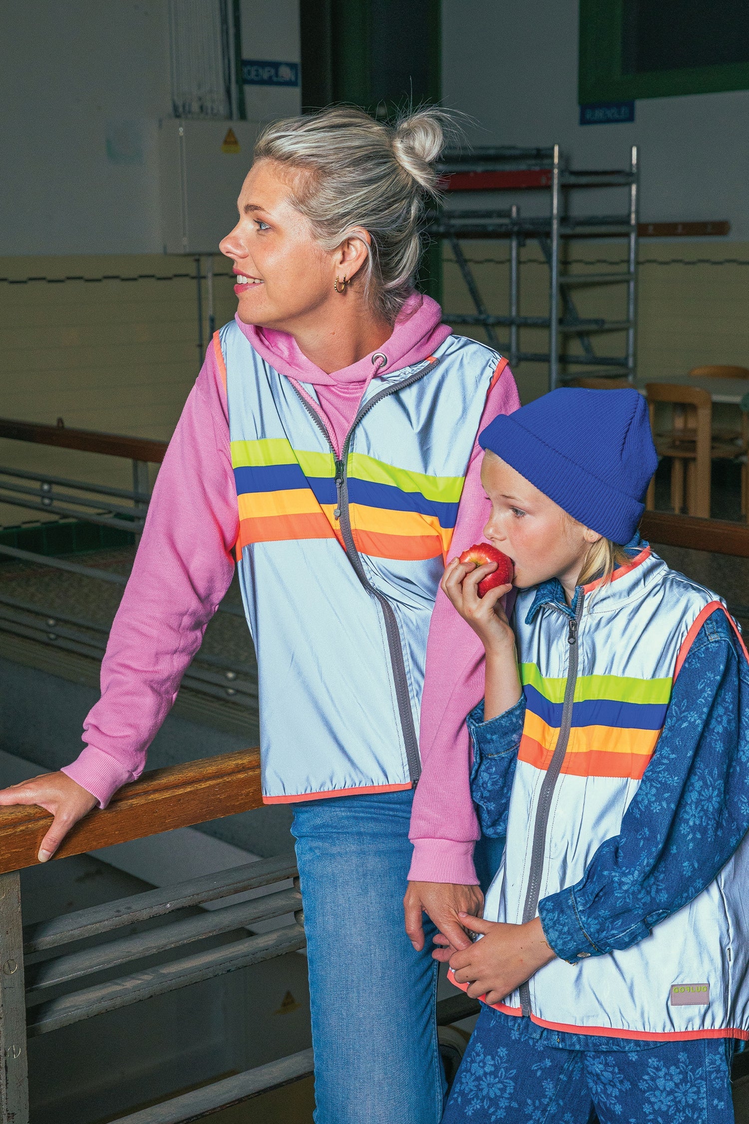 Two people wearing colorful jackets in an indoor setting