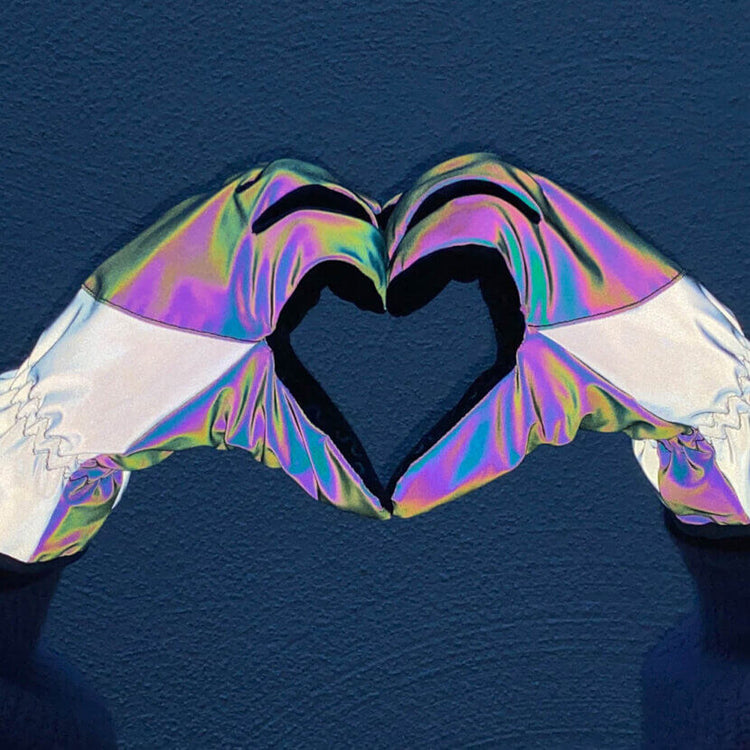 Iridescent inflatable pool float shaped like a heart on a blue background