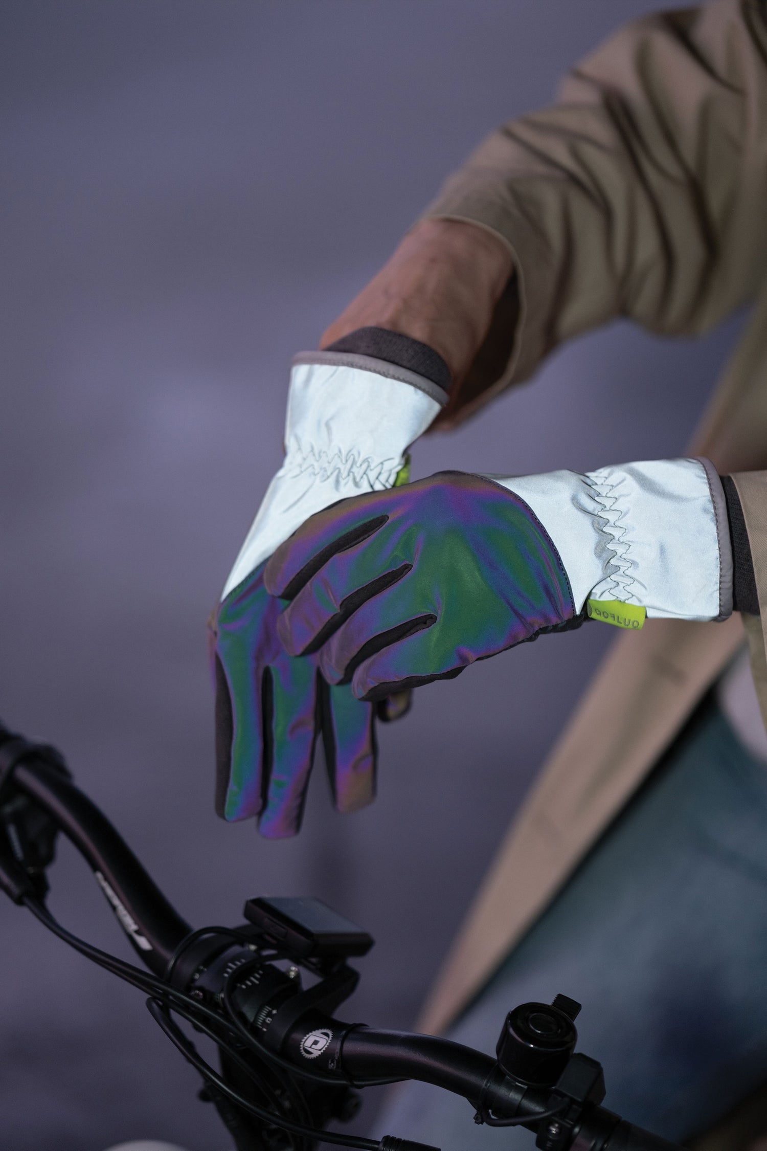 Close-up of a gloved hand on a bicycle handlebar with a blurred background