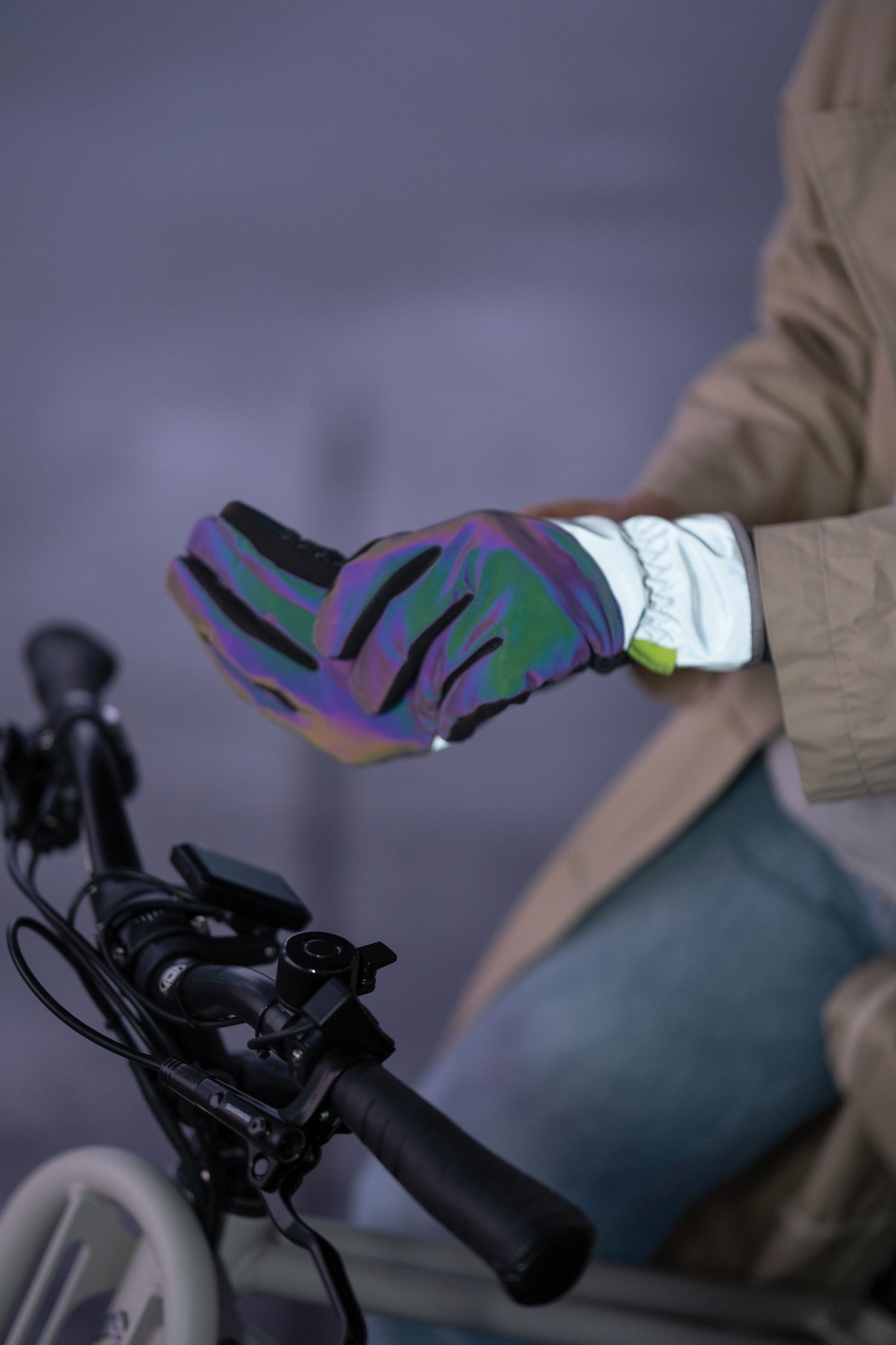 Person wearing a colorful glove on a bicycle against a blurred background