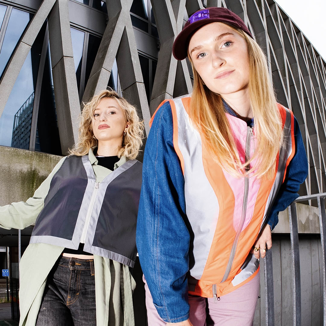 Two young women standing in front of a modern architectural structure.