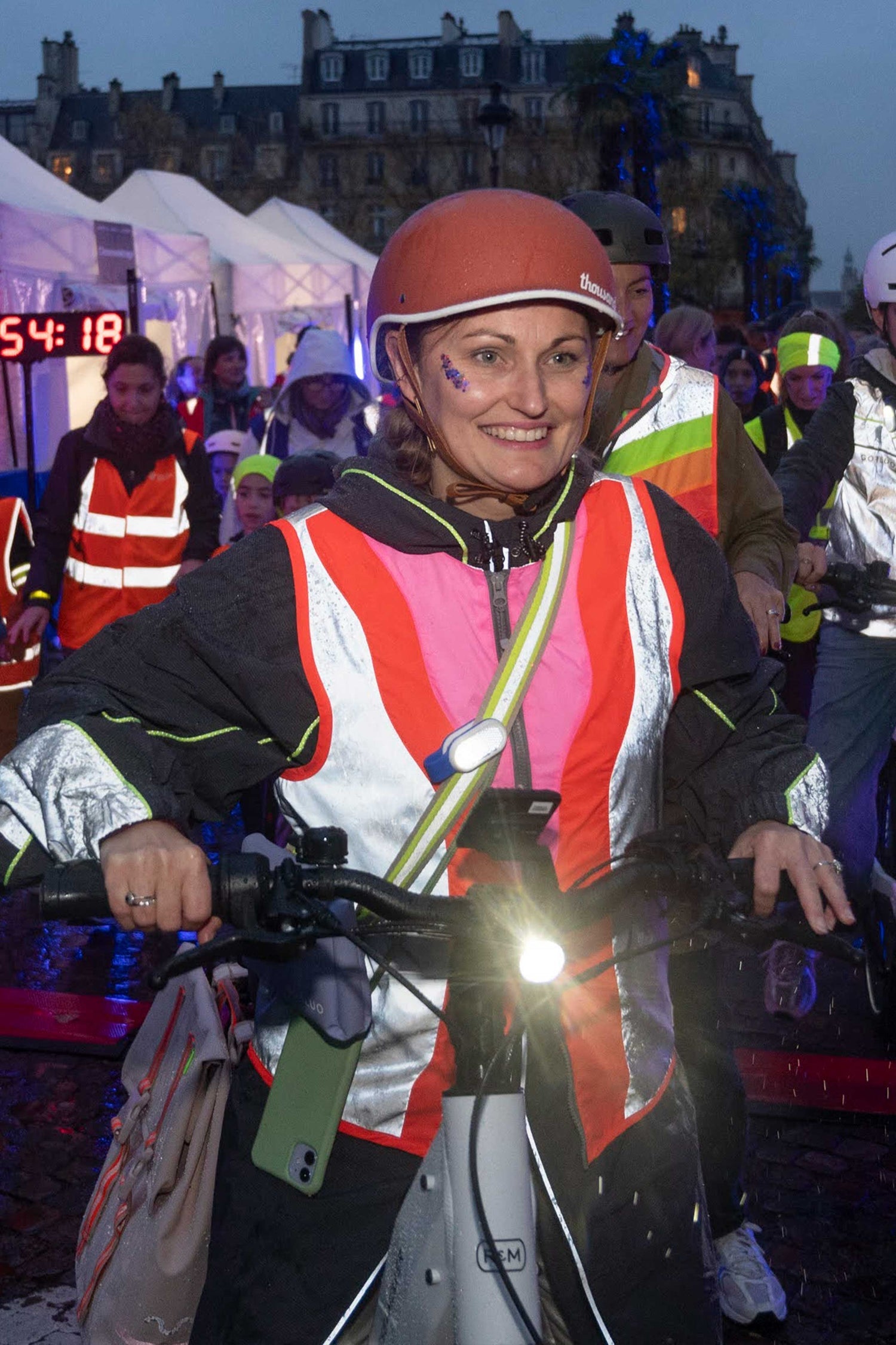 Person wearing a reflective safety jacket with a helmet in an outdoor setting