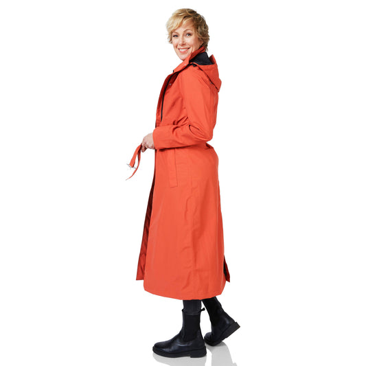 Woman wearing an orange trench coat on a white background