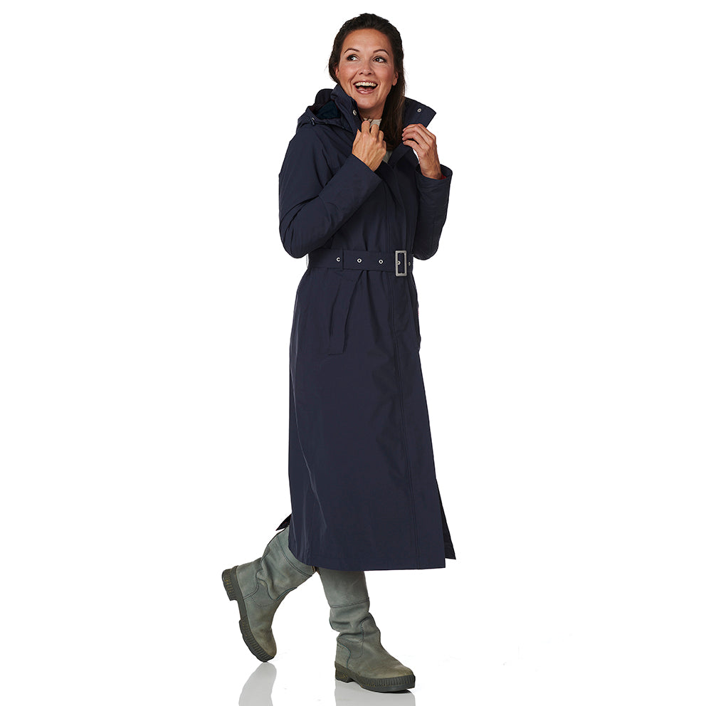 Woman wearing a long navy coat on a white background