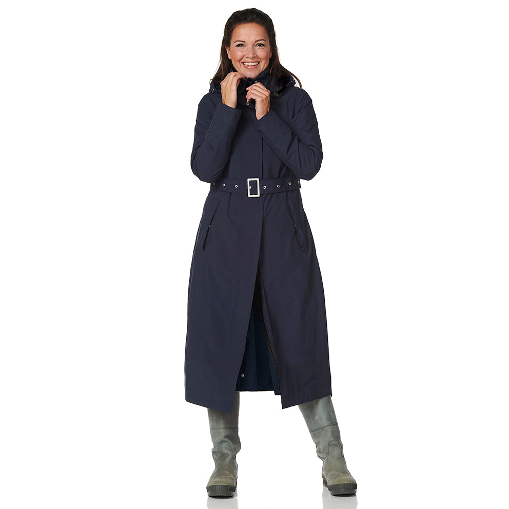 Woman wearing a long navy coat on a white background