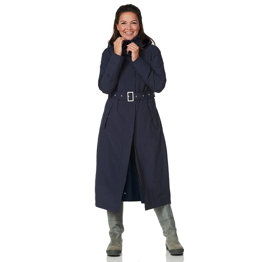 Woman wearing a long navy coat on a white background