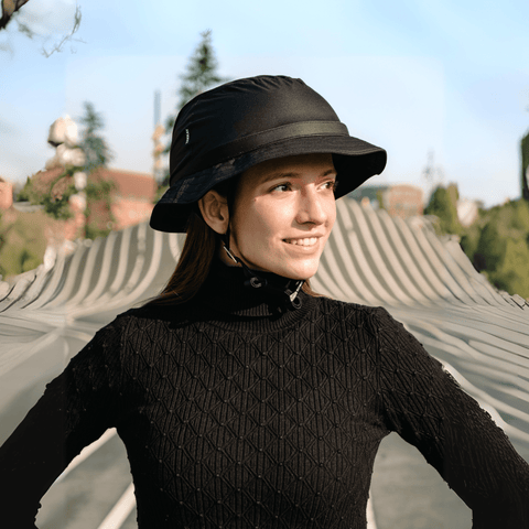 Person wearing a black bucket hat and black turtleneck sweater outdoors.